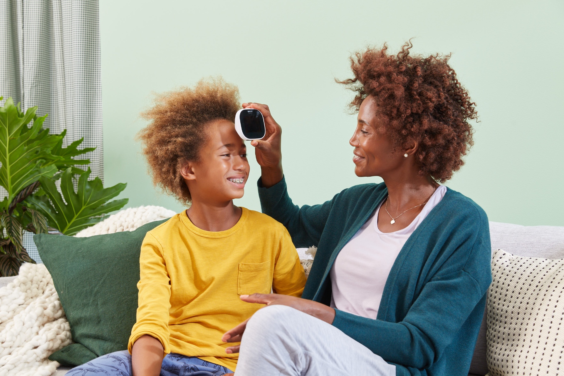 Mãe e filho sorrindo durante uso do TYTO CARE